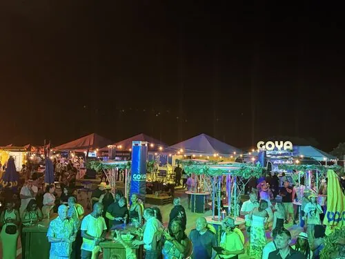 Guests gathered under the lit GOYA pavilion at night
