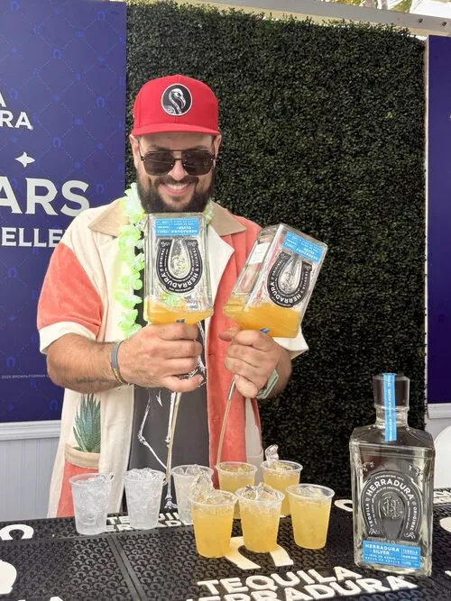 Bartender holding two Tequila Herradura cocktails at the bar