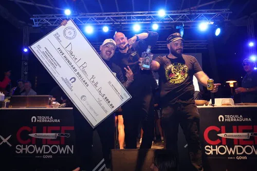 Chef Showdown winner holding an oversized Tequila Herradura prize check